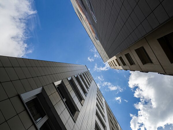 Blick zwischen zwei Plattenbauten in den blauen Himmel