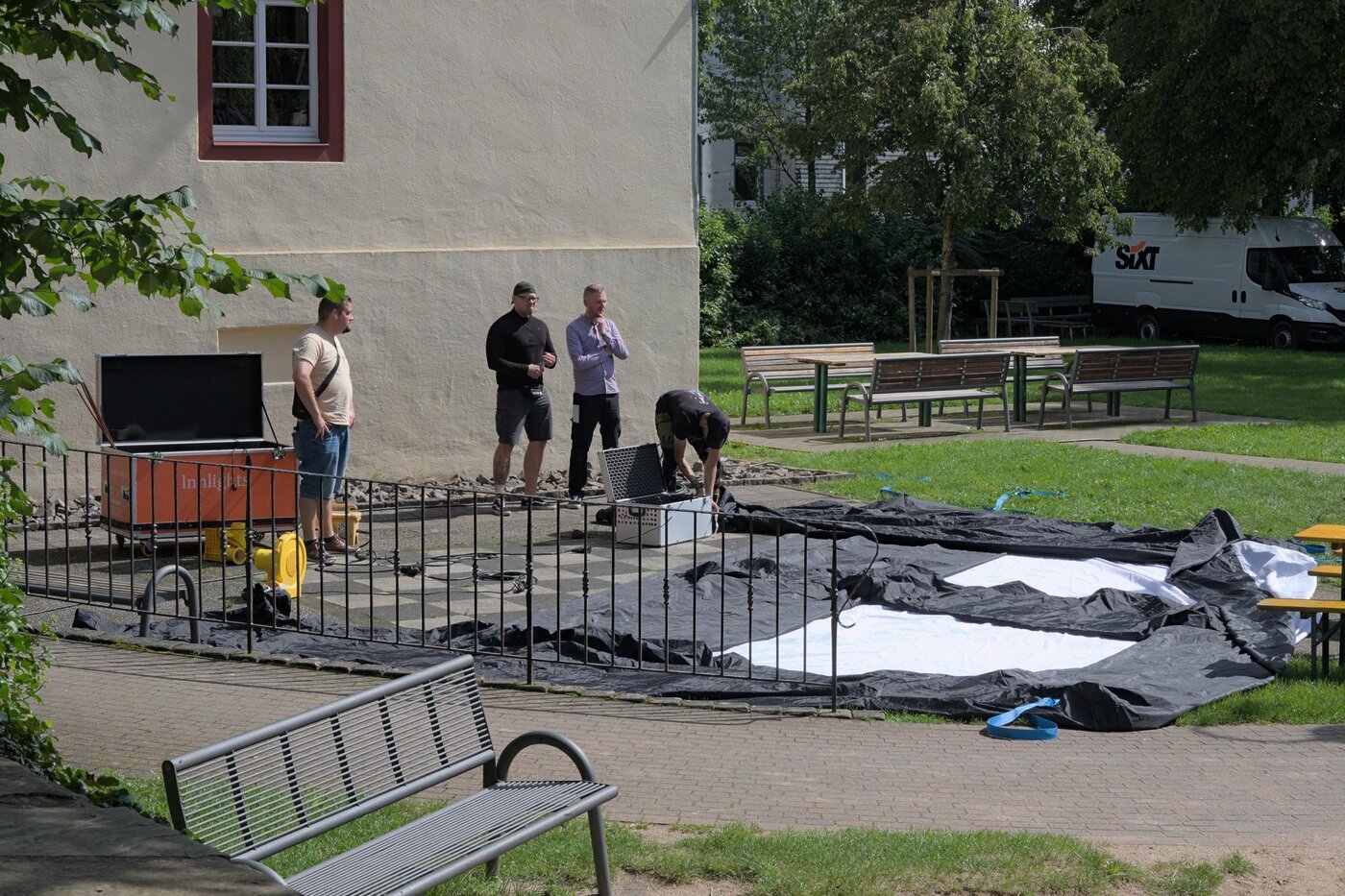 Mehrere Personen vor einer unaufgeblasenen Hüpfburg