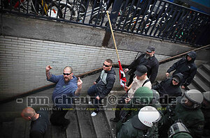 Personen einer rechten Demonstration laufen die Treppe an einem Bahnhof herunter.