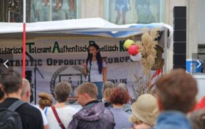 Eine Person spricht von einer Bühne auf einer Demonstration