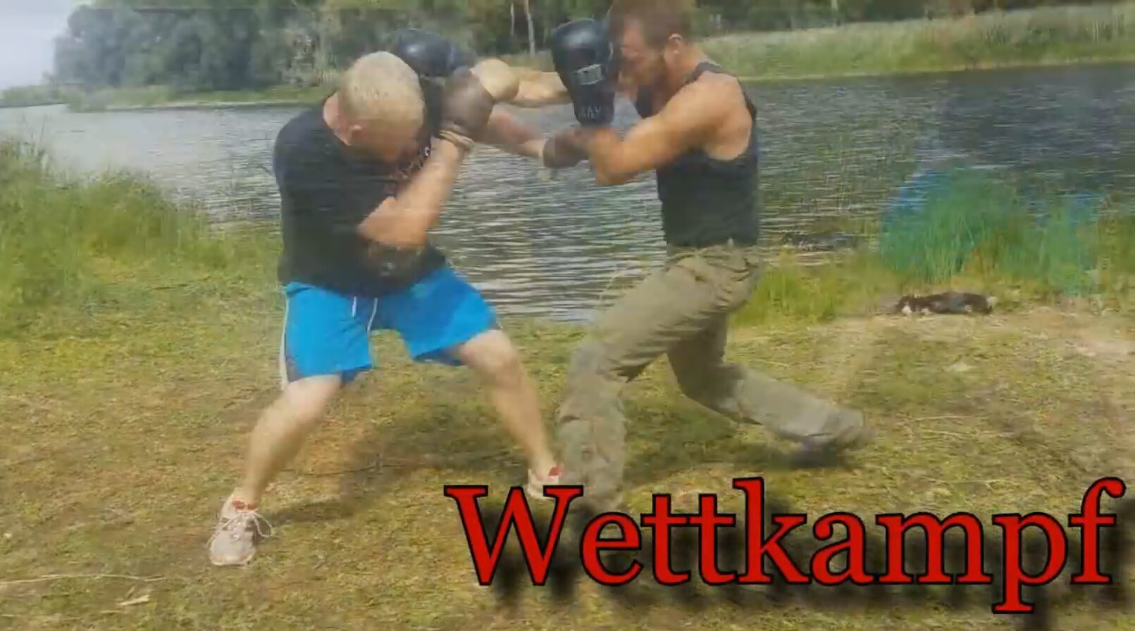 Zwei boxende Personen an einem Fluss.