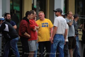 Mehrere Personen am Rande einer rechten Demonstration.