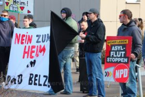 Personen mit Fahnen und Bannern auf einer rechten Kundgebung.