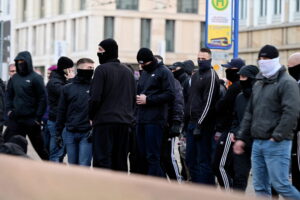 Vermummte Personen am Rande einer rechten Demonstration.