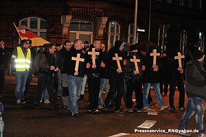 Eine rechte Demonstration. Die Teilnehmenden tragen hölzerne Kreuzer vor der Brust