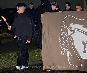 Personen an einem Transparent auf einer rechten Demonstration