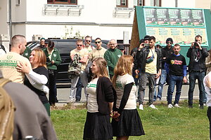 Personen tanzen mit Publikum auf einer Wiese.