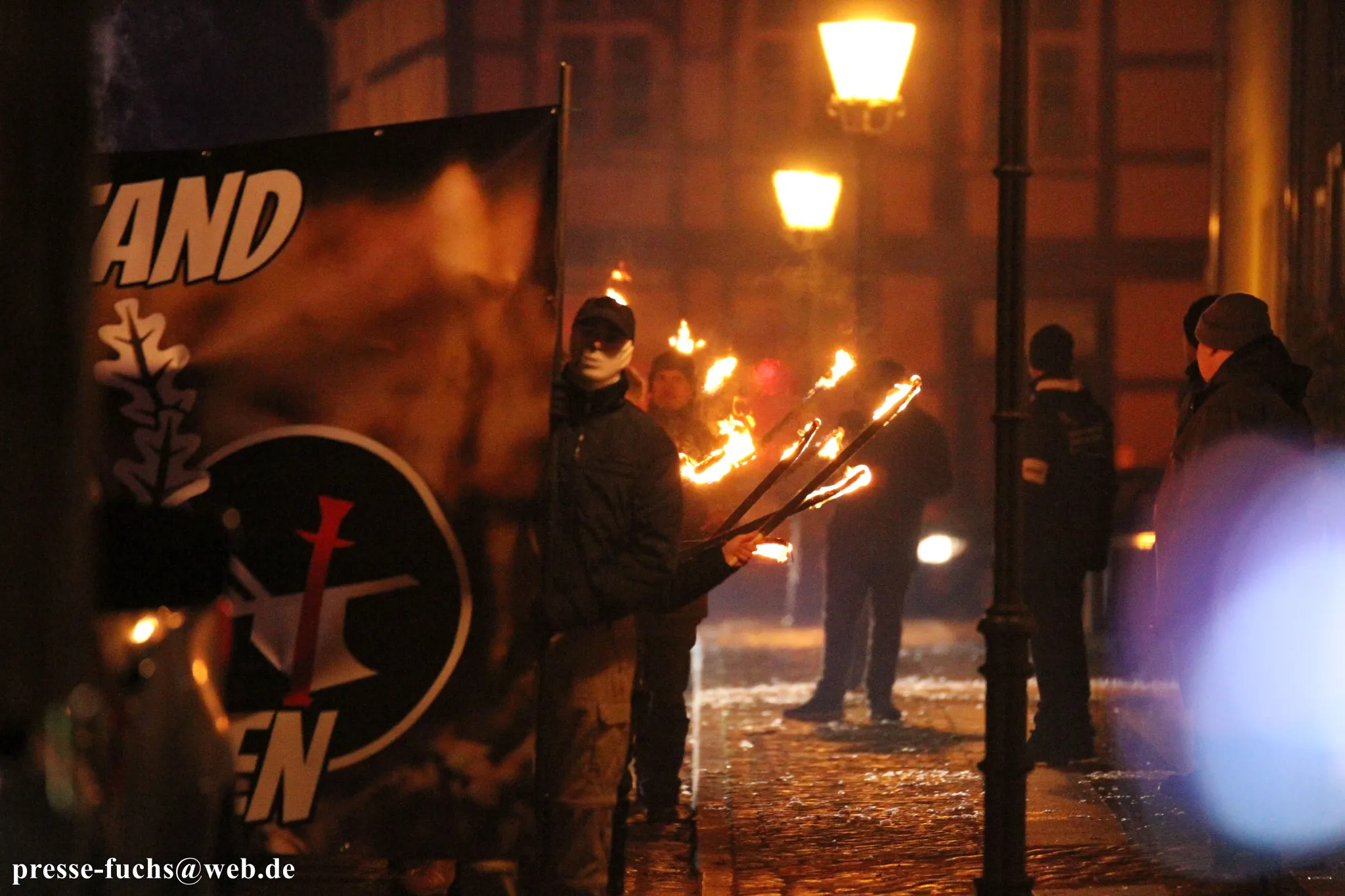 Personen mit Fackeln auf einer rechten Demonstration.