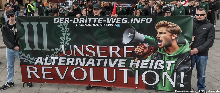 Personen halten ein Banner mit der Aufschrift "Unsere Alternative heißt Revolution!"