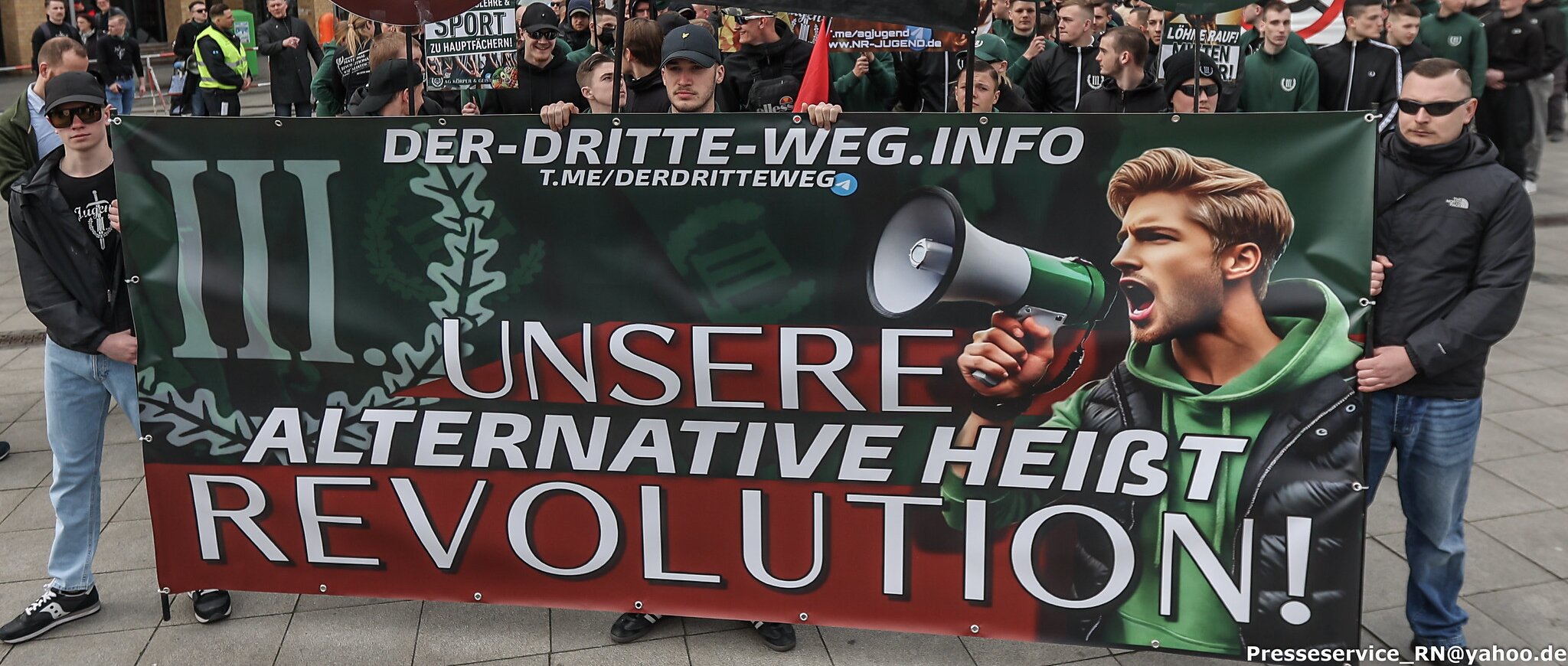 Personen halten ein Banner mit der Aufschrift "Unsere Alternative heißt Revolution!"