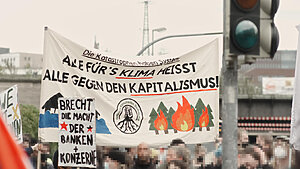Hochtransparent mit der Aufschrift "Die Katastrophen haben System: Alle Fürs Klima heißt alle gegen den Kapitalismus"