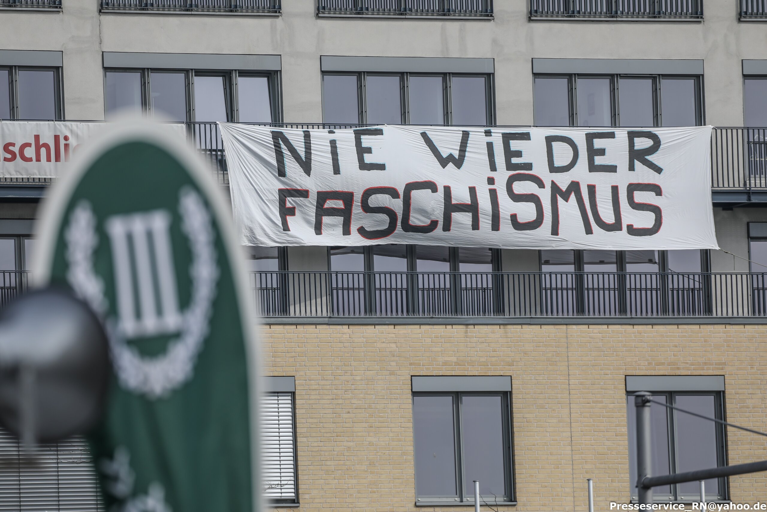 Ein Transparent mit der Aufschrift "Nie wieder Faschismus" vor einem Aufsteller der Partei "Der III. Weg"
