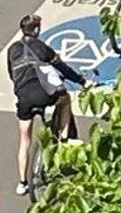 Eine Person auf einem Fahrrad, in der Hand hält sie einen Hammer.
