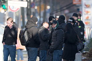 Eine dunkel gekleidete Personengruppe
